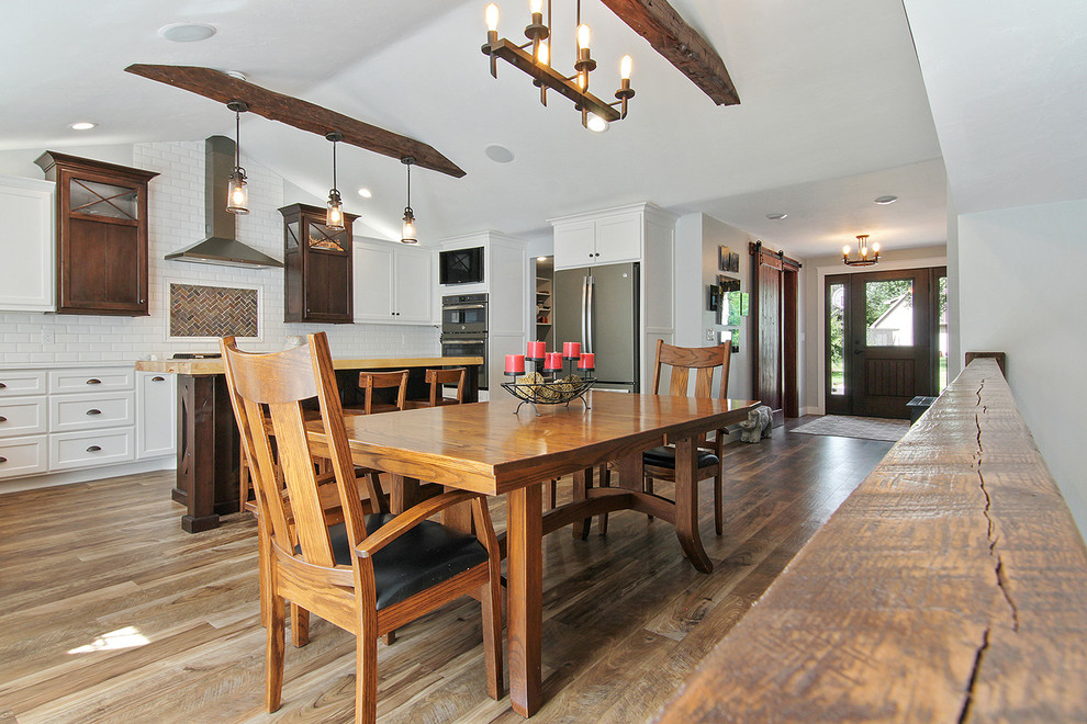 Foto di una grande sala da pranzo aperta verso la cucina country con pareti grigie, pavimento in vinile e pavimento verde