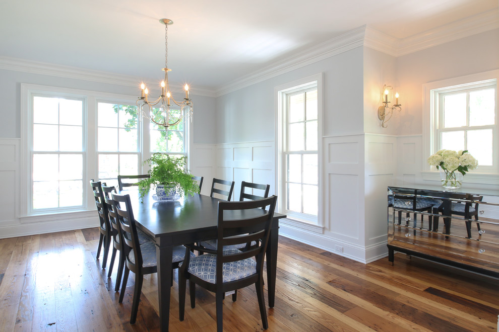 Cette photo montre une salle à manger ouverte sur le salon nature avec un mur bleu et un sol en bois brun.