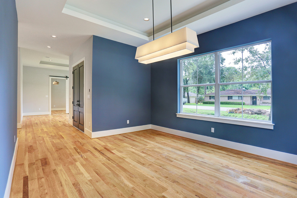 Photo of a contemporary dining room in Houston with light hardwood flooring.