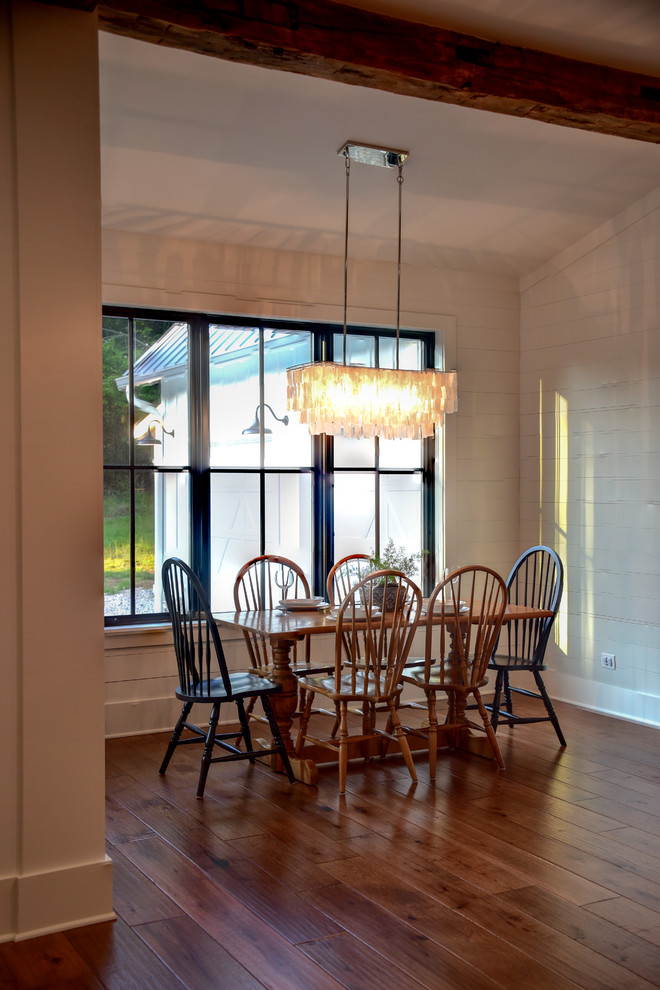 Aménagement d'une petite salle à manger ouverte sur le salon campagne avec un mur blanc, un sol en bois brun et un sol marron.