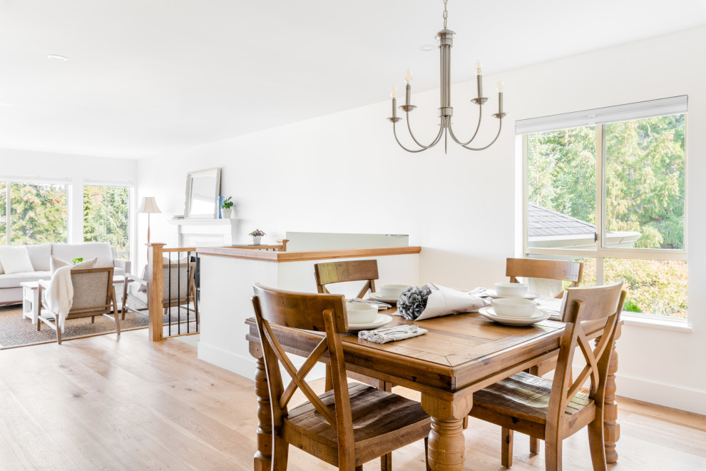Example of a mid-sized country medium tone wood floor and brown floor kitchen/dining room combo design in Vancouver with white walls