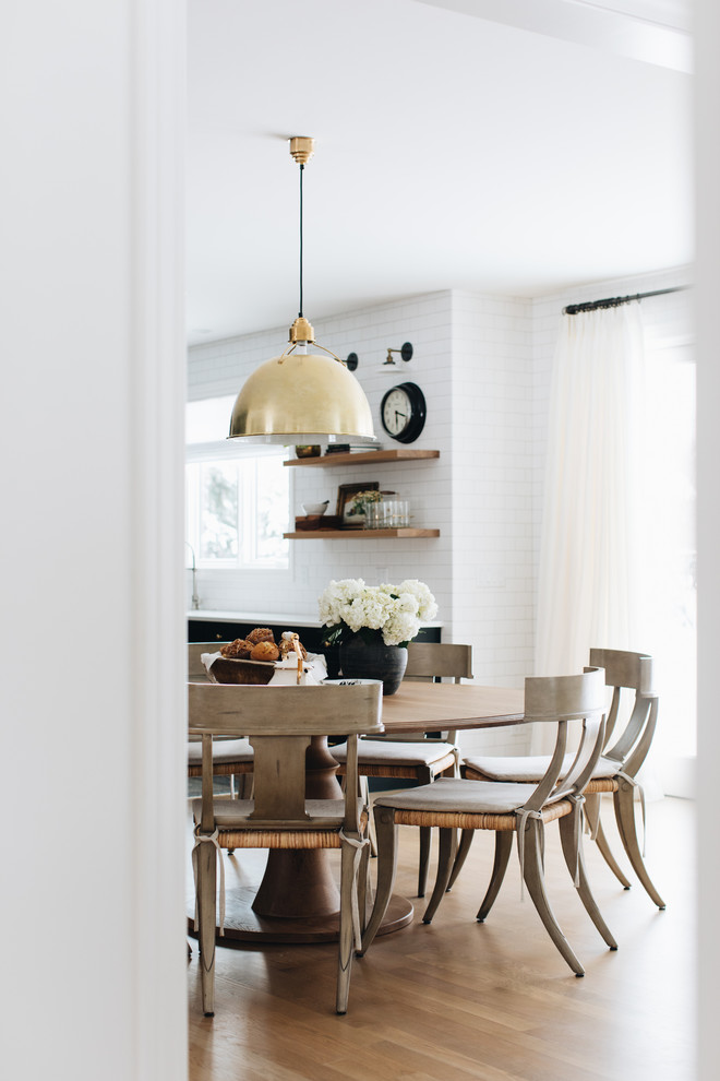 Ispirazione per una grande sala da pranzo aperta verso la cucina tradizionale con pareti bianche, parquet chiaro e pavimento marrone