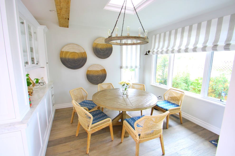 Idee per una sala da pranzo aperta verso la cucina stile marinaro di medie dimensioni con pareti bianche, pavimento in legno massello medio e pavimento marrone