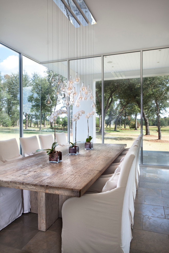 Idee per un'ampia sala da pranzo aperta verso la cucina design con pareti bianche e pavimento in pietra calcarea