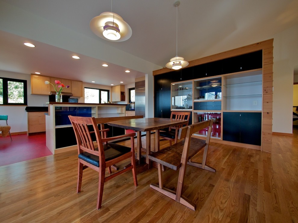This is an example of a modern kitchen/dining room in Seattle with beige walls and medium hardwood flooring.