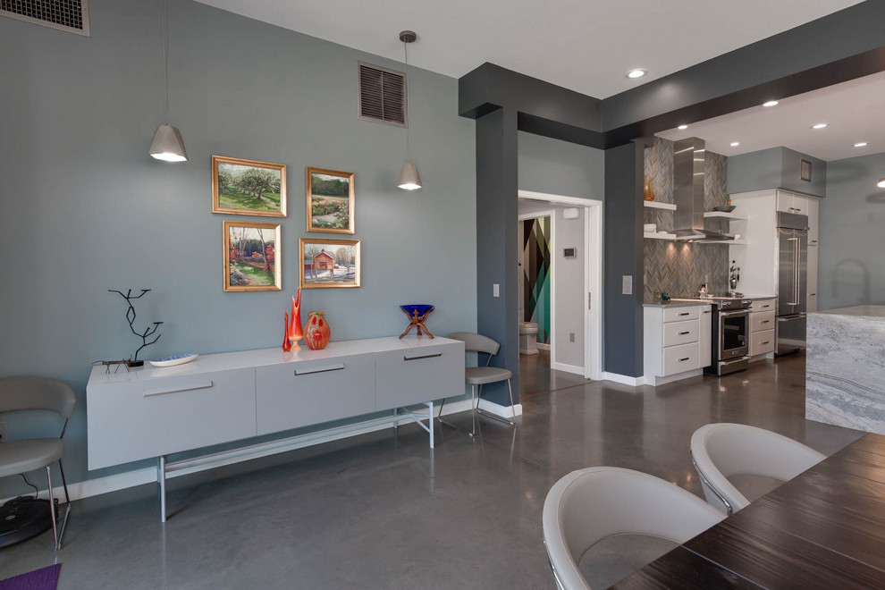 Foto di una sala da pranzo aperta verso il soggiorno industriale di medie dimensioni con pareti blu, pavimento in cemento e pavimento grigio