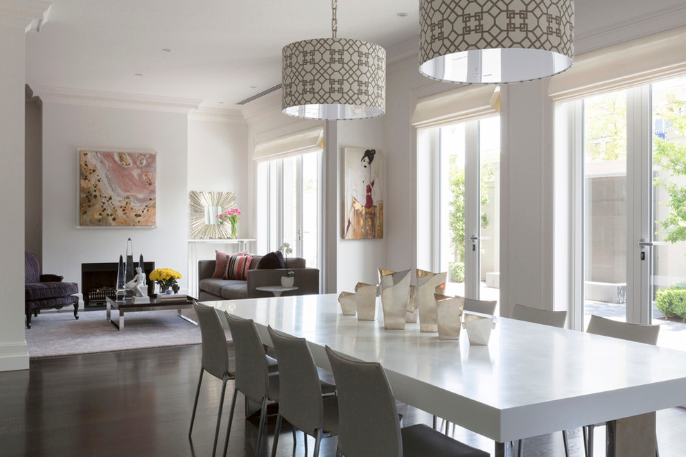 Idées déco pour une grande salle à manger ouverte sur la cuisine contemporaine avec un mur blanc, parquet foncé, une cheminée standard, un manteau de cheminée en plâtre et un sol marron.