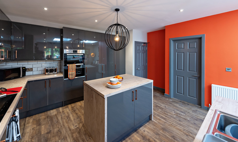 Cette image montre une cuisine design de taille moyenne avec parquet clair et un sol marron.