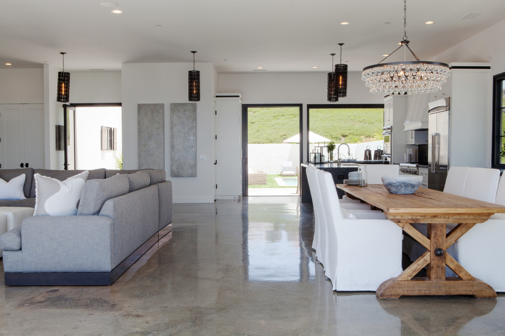 Photo of a contemporary open plan dining room in Orange County with white walls and concrete flooring.