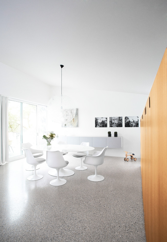 This is an example of a modern dining room in Other with white walls.