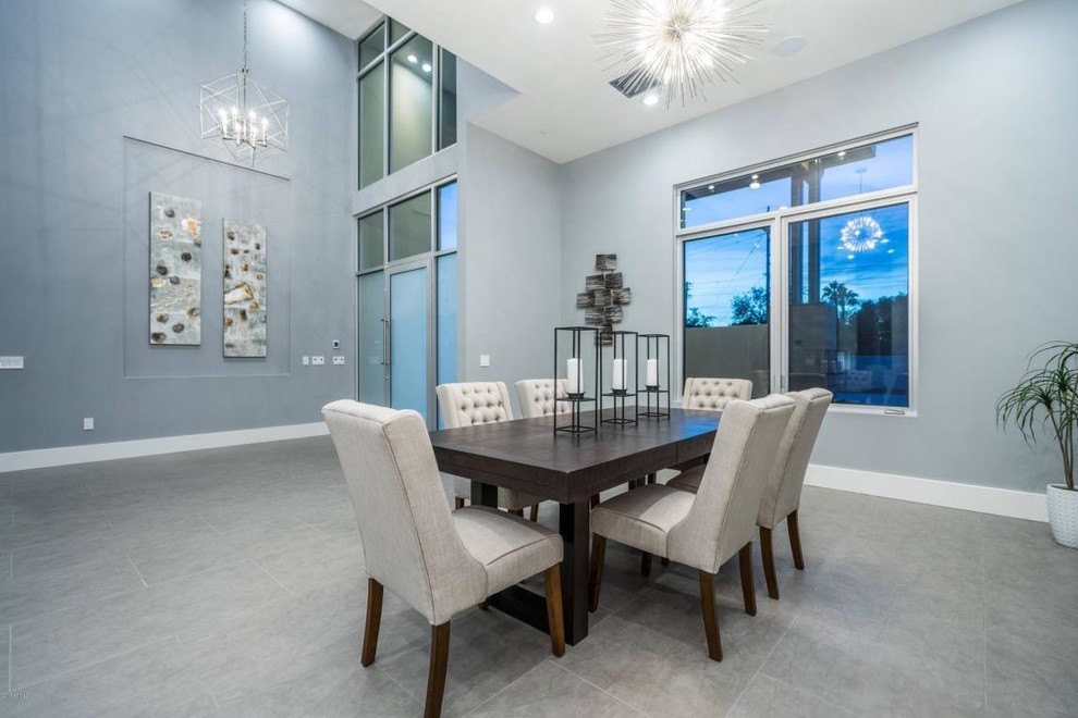 Immagine di un'ampia sala da pranzo aperta verso il soggiorno moderna con pareti blu, pavimento in gres porcellanato e pavimento grigio