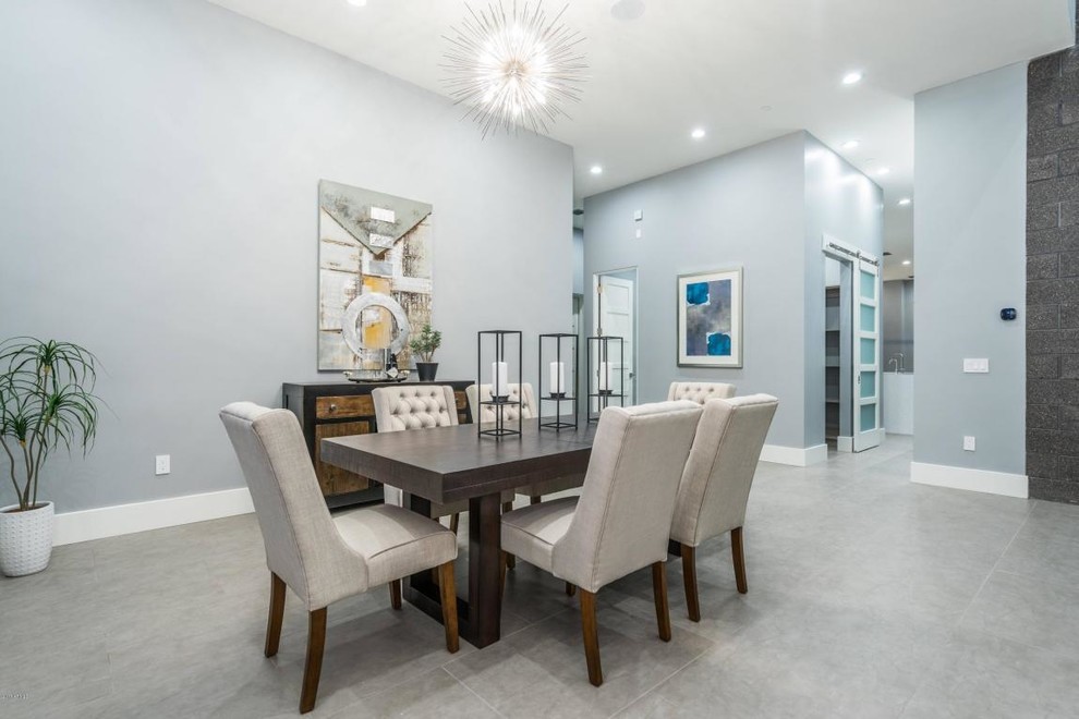 Idee per un'ampia sala da pranzo aperta verso il soggiorno moderna con pareti blu, pavimento in gres porcellanato e pavimento grigio