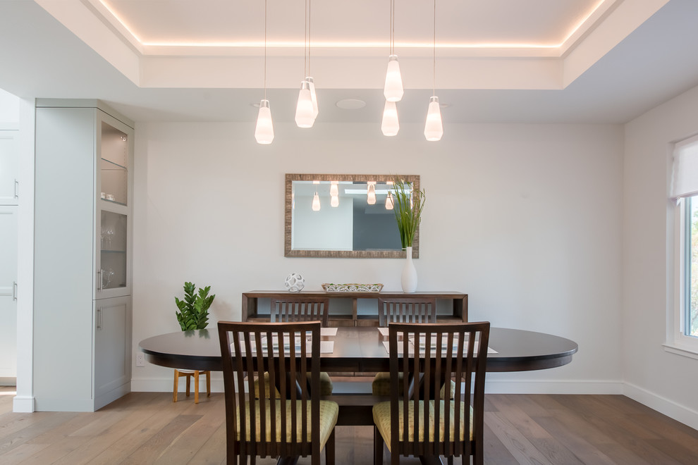 Idée de décoration pour une salle à manger ouverte sur la cuisine minimaliste de taille moyenne avec un mur gris, un sol en bois brun, aucune cheminée et un sol marron.