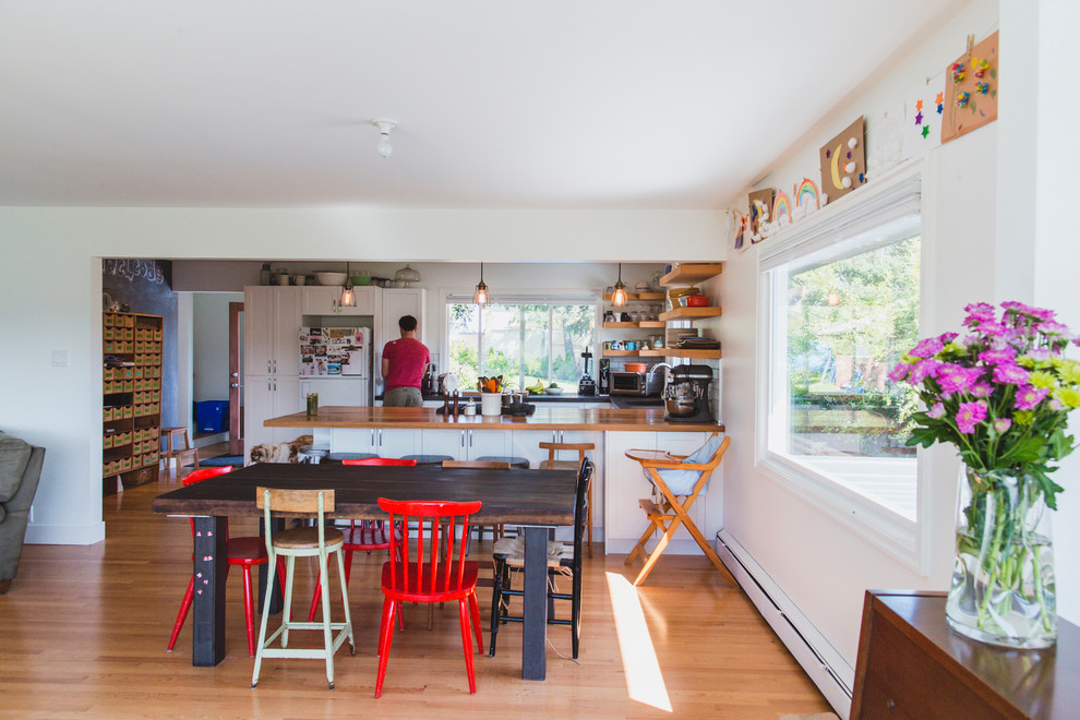 Moderne Wohnküche mit weißer Wandfarbe und hellem Holzboden in Vancouver