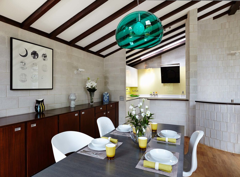 Exemple d'une grande salle à manger ouverte sur le salon tendance avec un mur gris, parquet clair et aucune cheminée.
