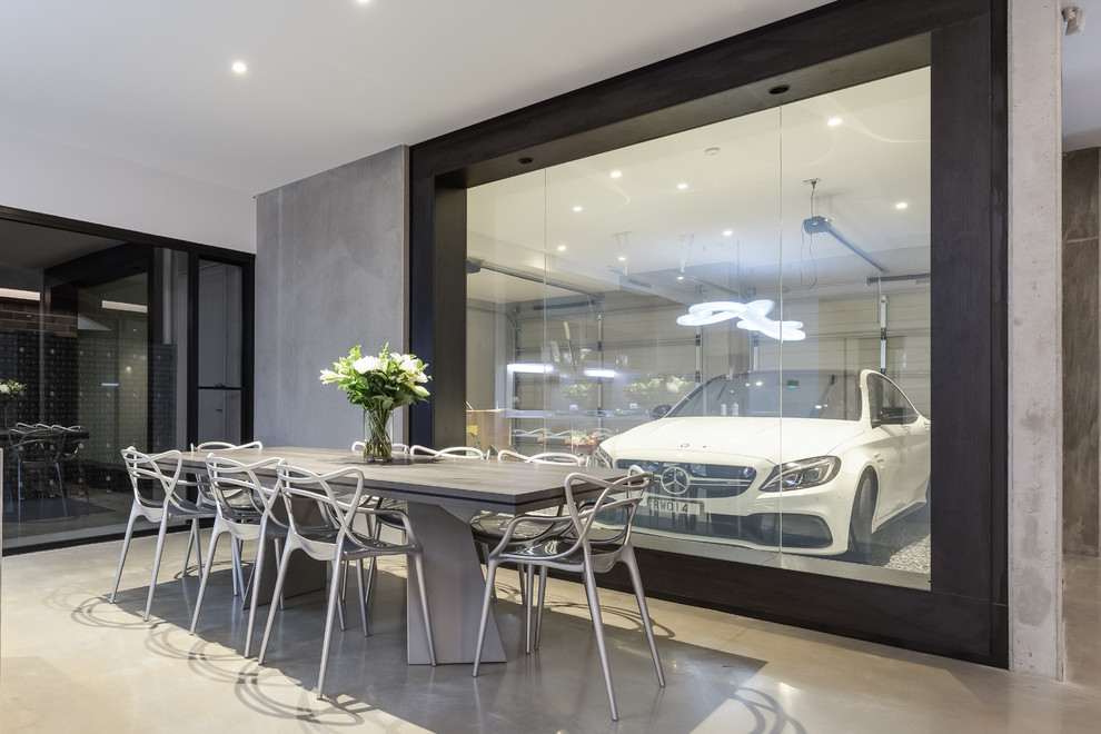 Immagine di una sala da pranzo aperta verso la cucina industriale di medie dimensioni con pareti beige, pavimento in cemento e pavimento beige