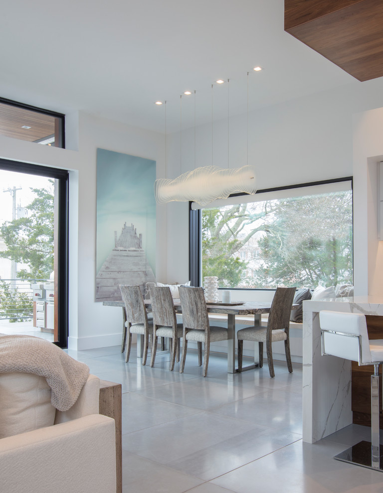 Inspiration pour une grande salle à manger ouverte sur le salon minimaliste avec un mur blanc, sol en béton ciré et un sol gris.