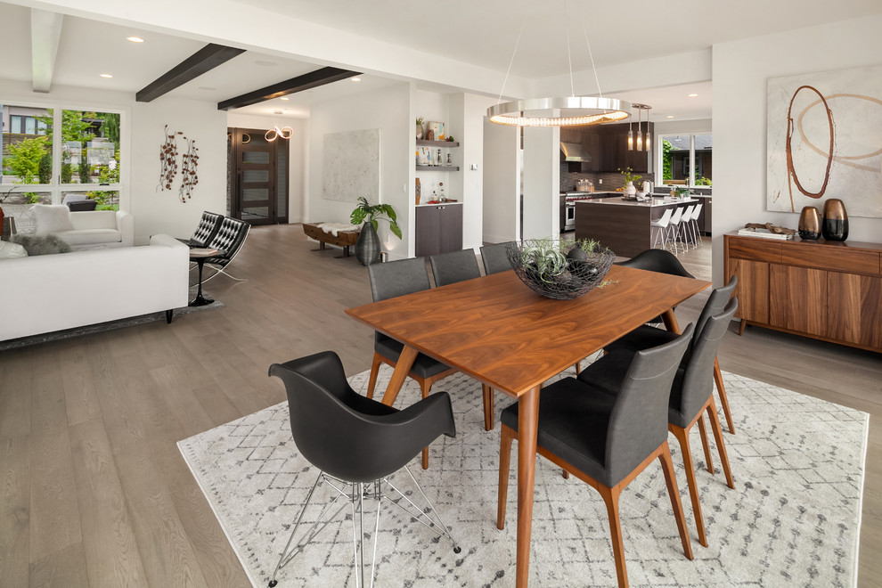 Idee per una sala da pranzo aperta verso il soggiorno minimalista con pareti bianche, parquet chiaro e pavimento beige