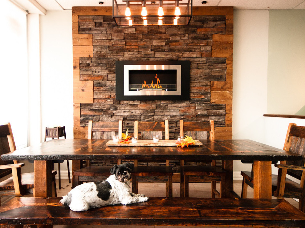 Dining room - mid-sized rustic dining room idea in Denver with a hanging fireplace and a metal fireplace