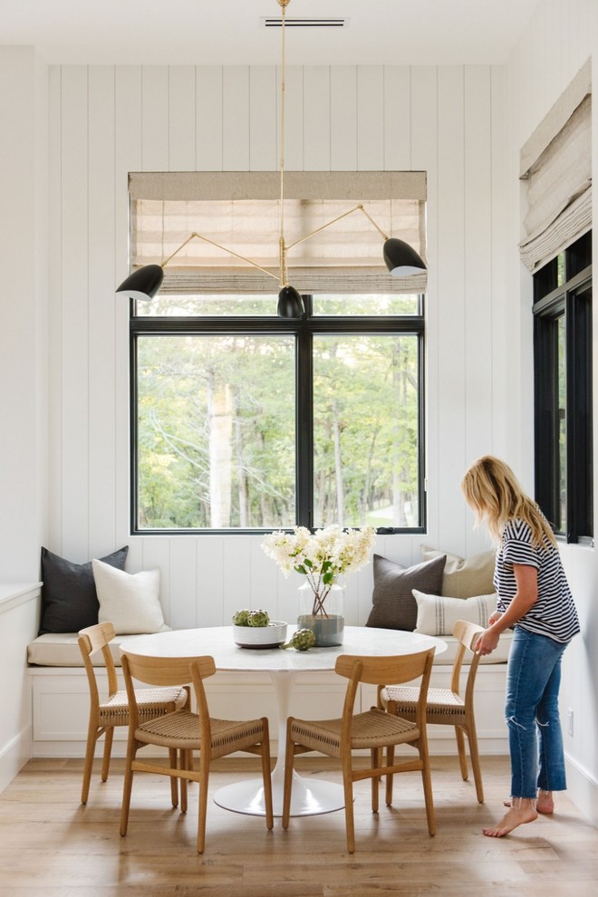 Idée de décoration pour une salle à manger champêtre fermée et de taille moyenne avec un mur blanc et parquet clair.
