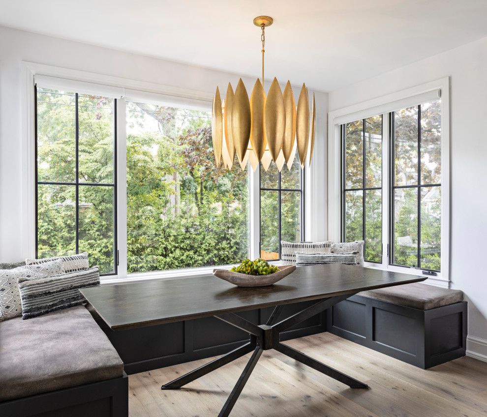 Idées déco pour une grande salle à manger contemporaine avec une banquette d'angle, un mur blanc, parquet clair, une cheminée standard, un manteau de cheminée en pierre et un sol beige.