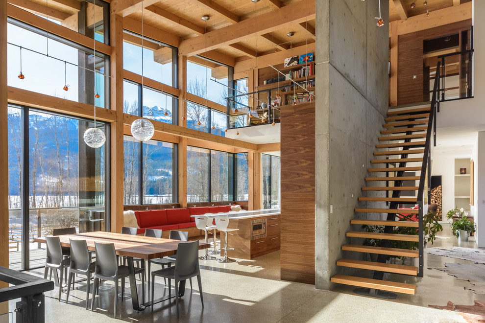 Photo of a modern dining room in Vancouver with white walls and concrete flooring.