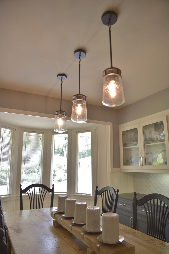 Cette photo montre une salle à manger ouverte sur la cuisine nature avec un mur gris et un sol marron.