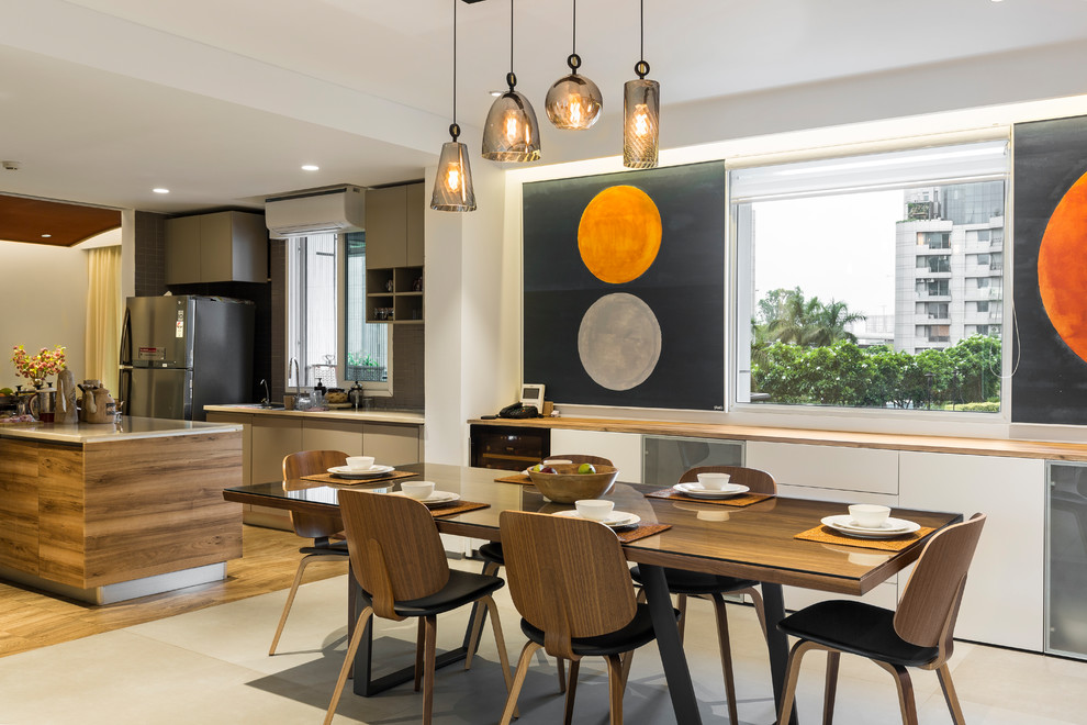 This is an example of a contemporary kitchen/dining room in Delhi with white walls and grey floors.