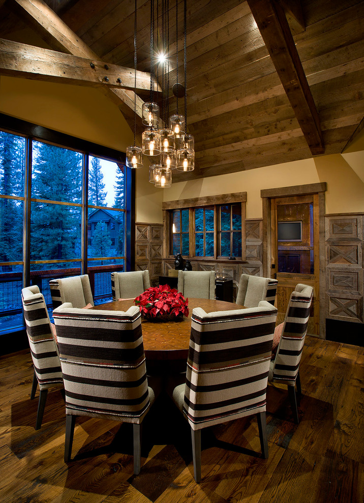 Immagine di una grande sala da pranzo stile rurale con pareti beige, parquet scuro e pavimento marrone