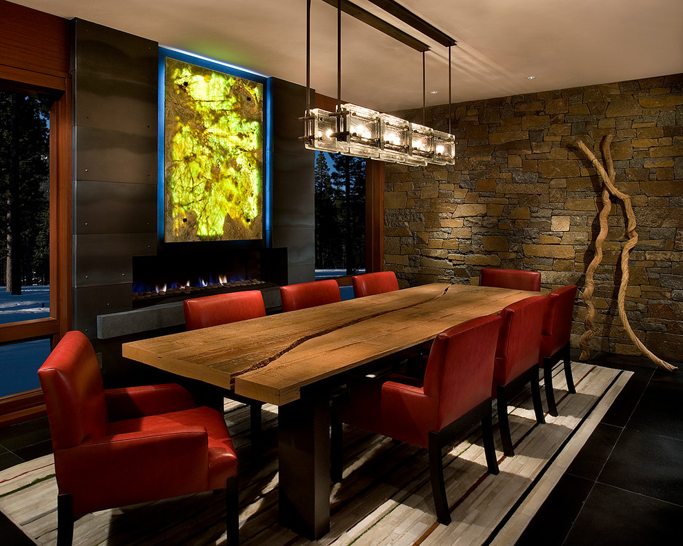 Immagine di una grande sala da pranzo minimal con cornice del camino in metallo e pavimento nero