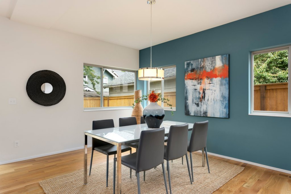 Mittelgroßes Modernes Esszimmer ohne Kamin mit hellem Holzboden und blauer Wandfarbe in Seattle