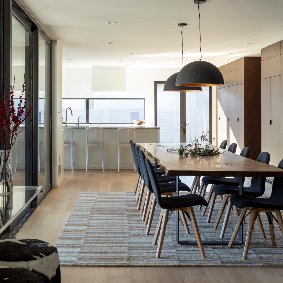 Foto di una grande sala da pranzo aperta verso il soggiorno contemporanea con pareti bianche, parquet chiaro e pavimento beige
