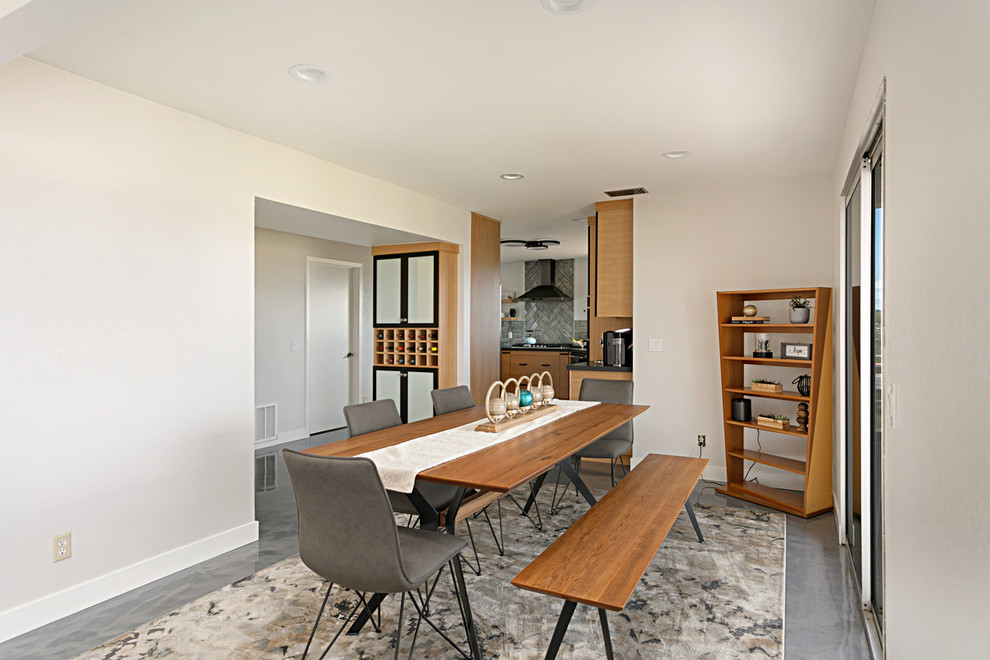На фото: кухня-столовая среднего размера в стиле модернизм с серыми стенами, бетонным полом и серым полом без камина с