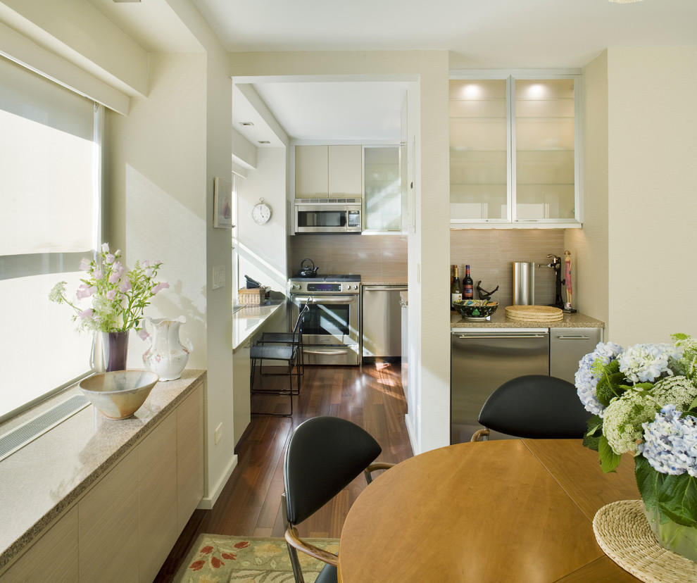 Diseño de comedor de cocina actual con paredes beige y suelo de madera oscura