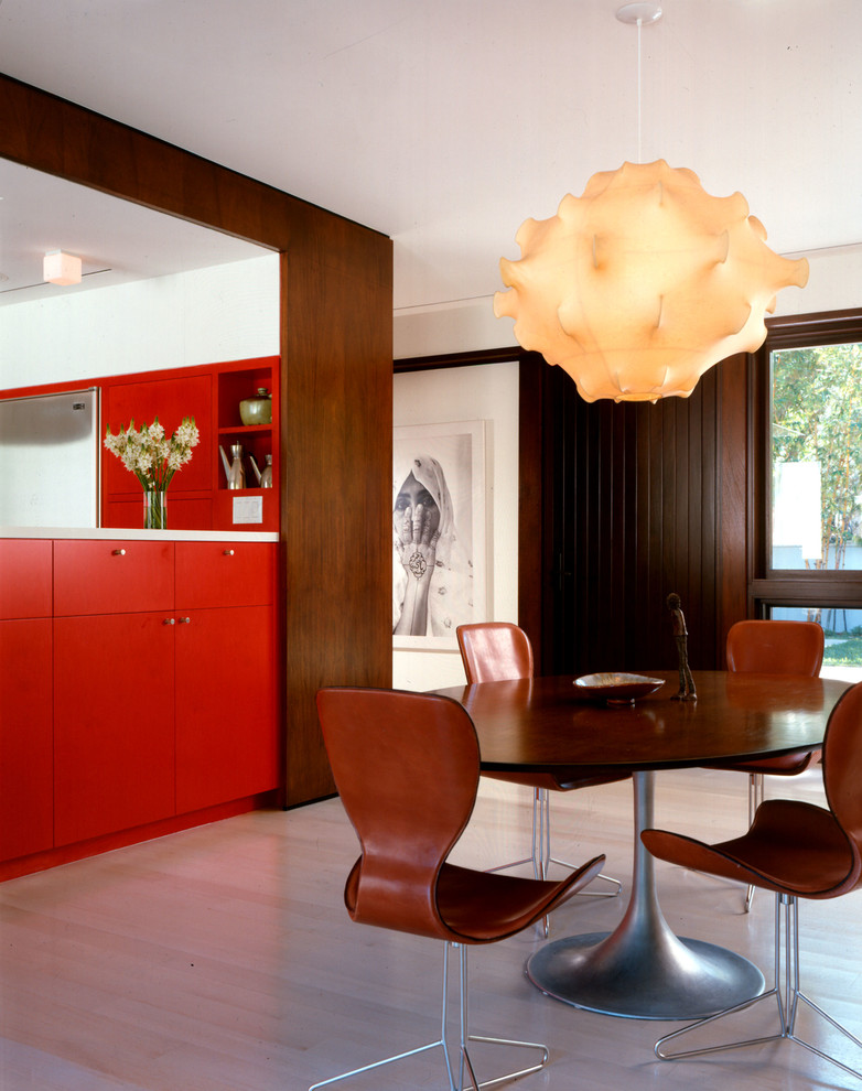Foto di una sala da pranzo aperta verso il soggiorno contemporanea con pareti marroni e parquet chiaro
