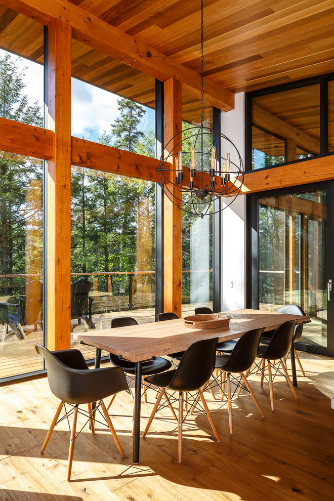 Inspiration pour une salle à manger chalet avec un sol en bois brun et aucune cheminée.
