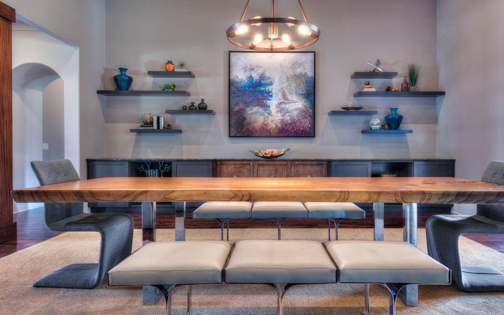 Cette photo montre une grande salle à manger ouverte sur la cuisine moderne avec un mur gris et un sol en bois brun.