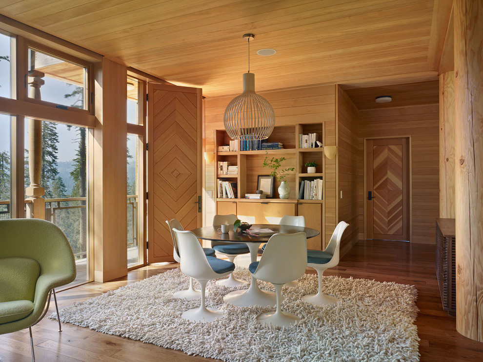 Cette image montre une très grande salle à manger ouverte sur le salon chalet avec un sol en bois brun et aucune cheminée.