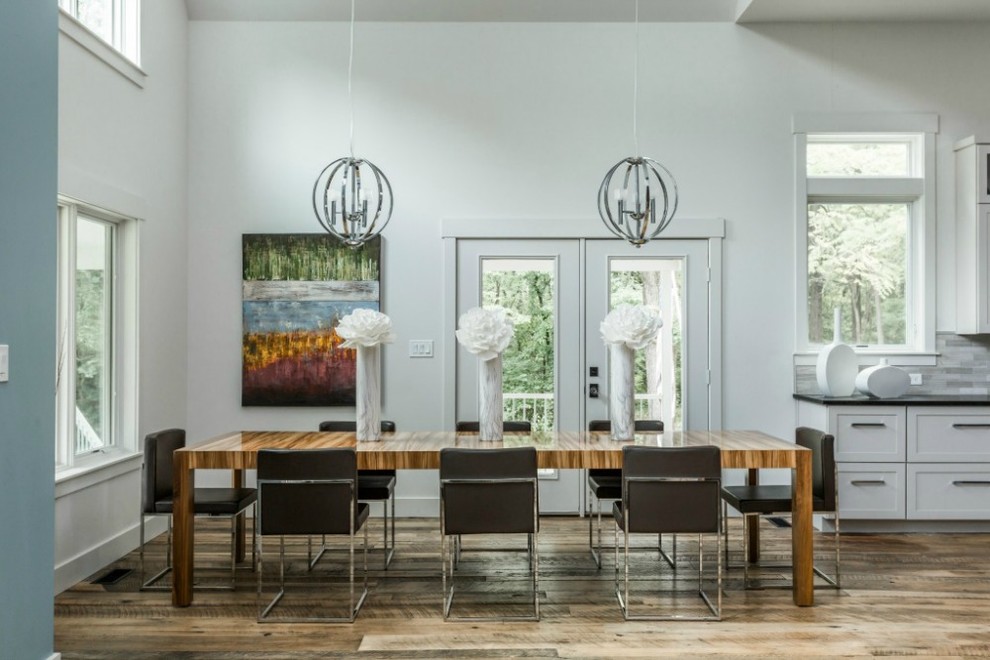 Ispirazione per una sala da pranzo aperta verso la cucina minimal con pareti bianche e pavimento in legno massello medio