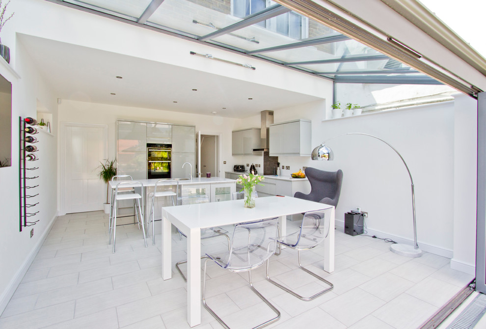 Réalisation d'une salle à manger design avec un mur blanc et un sol en carrelage de céramique.