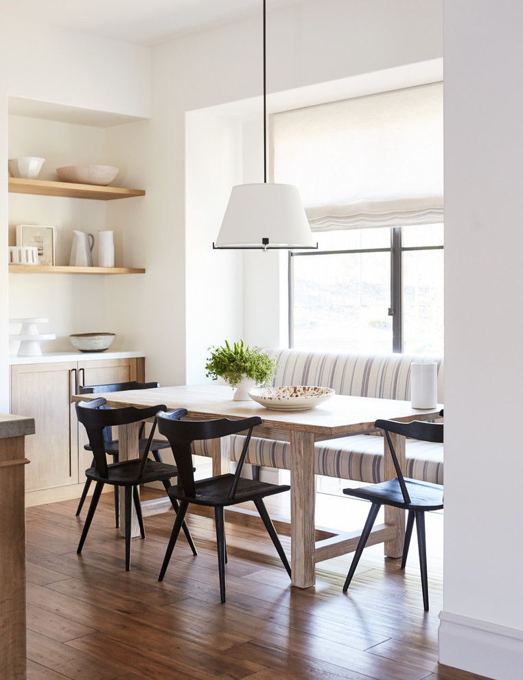 Aménagement d'une salle à manger ouverte sur la cuisine méditerranéenne de taille moyenne avec un sol en bois brun, un sol marron et un mur blanc.