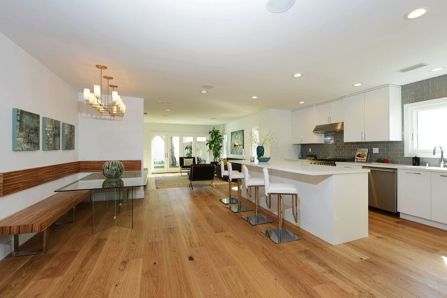 Ispirazione per una sala da pranzo aperta verso il soggiorno moderna di medie dimensioni con pareti bianche e pavimento in legno massello medio