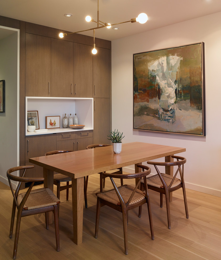 Cette image montre une petite salle à manger ouverte sur le salon vintage avec un mur blanc, parquet clair et un sol beige.