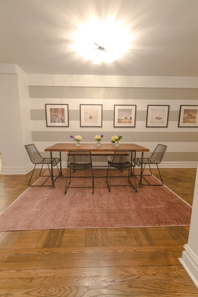 Immagine di una sala da pranzo moderna con pareti multicolore e pavimento in legno massello medio