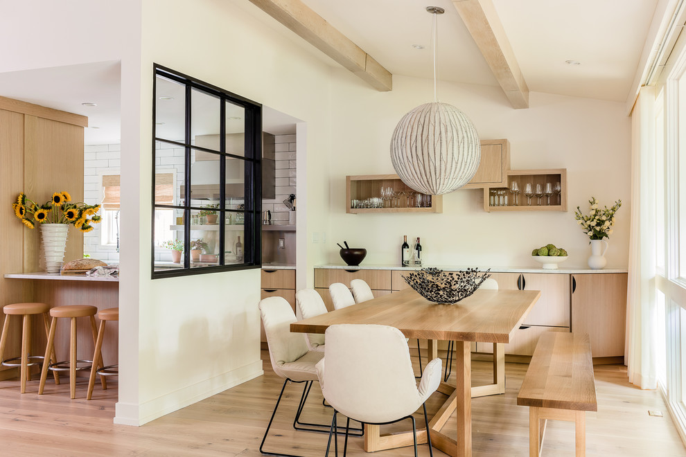 На фото: кухня-столовая в современном стиле с белыми стенами, светлым паркетным полом, бежевым полом и балками на потолке с