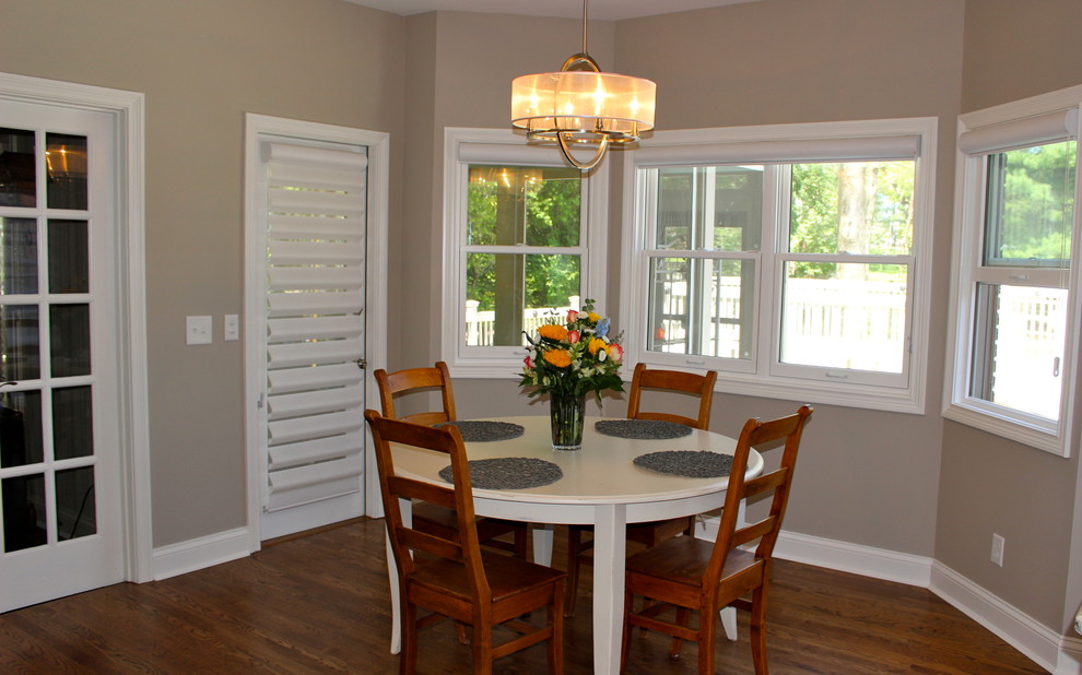 Aménagement d'une grande salle à manger ouverte sur la cuisine moderne avec un sol en bois brun, un mur beige et aucune cheminée.
