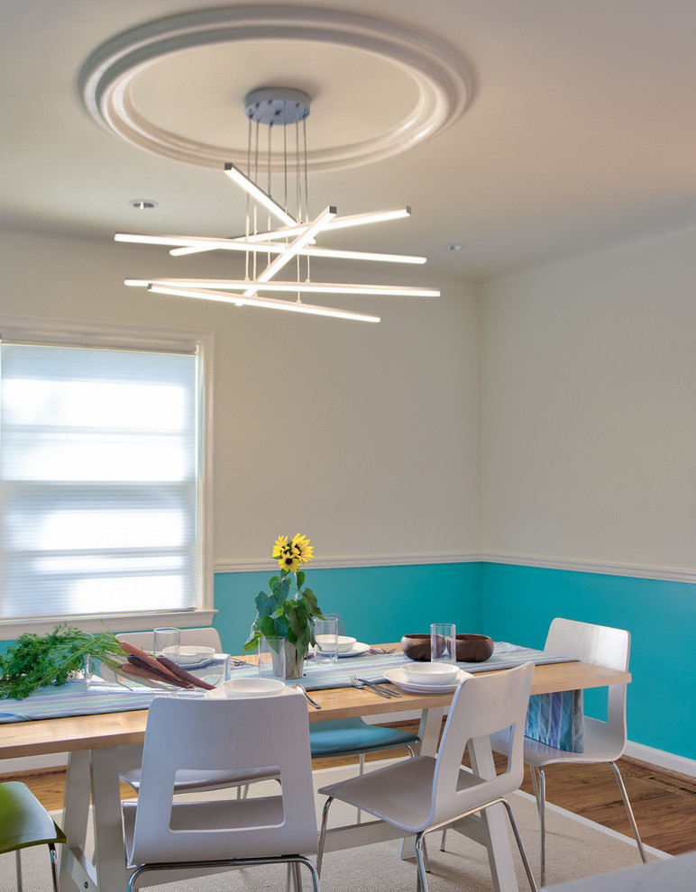 Immagine di una piccola sala da pranzo aperta verso il soggiorno moderna con pareti blu, pavimento in legno massello medio, nessun camino e pavimento marrone