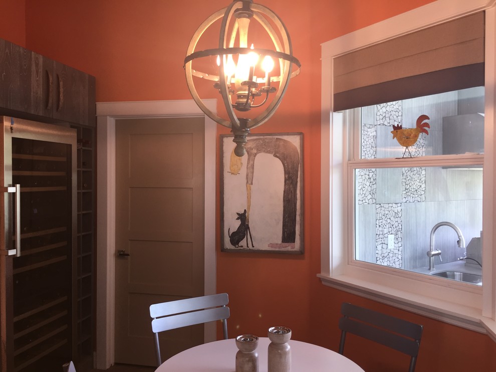 Ispirazione per una piccola sala da pranzo aperta verso la cucina boho chic con pareti arancioni