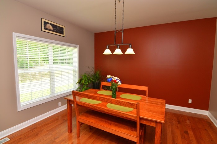 Dining room - craftsman medium tone wood floor dining room idea in Charlotte with red walls