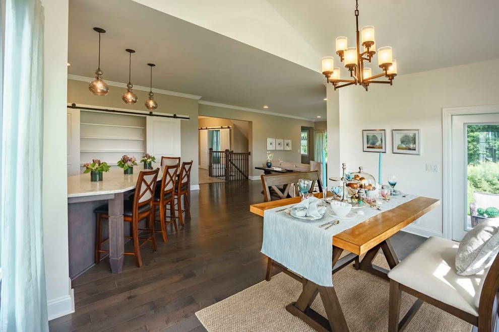 Immagine di una sala da pranzo aperta verso la cucina stile americano di medie dimensioni con pareti beige, parquet scuro, nessun camino e pavimento marrone